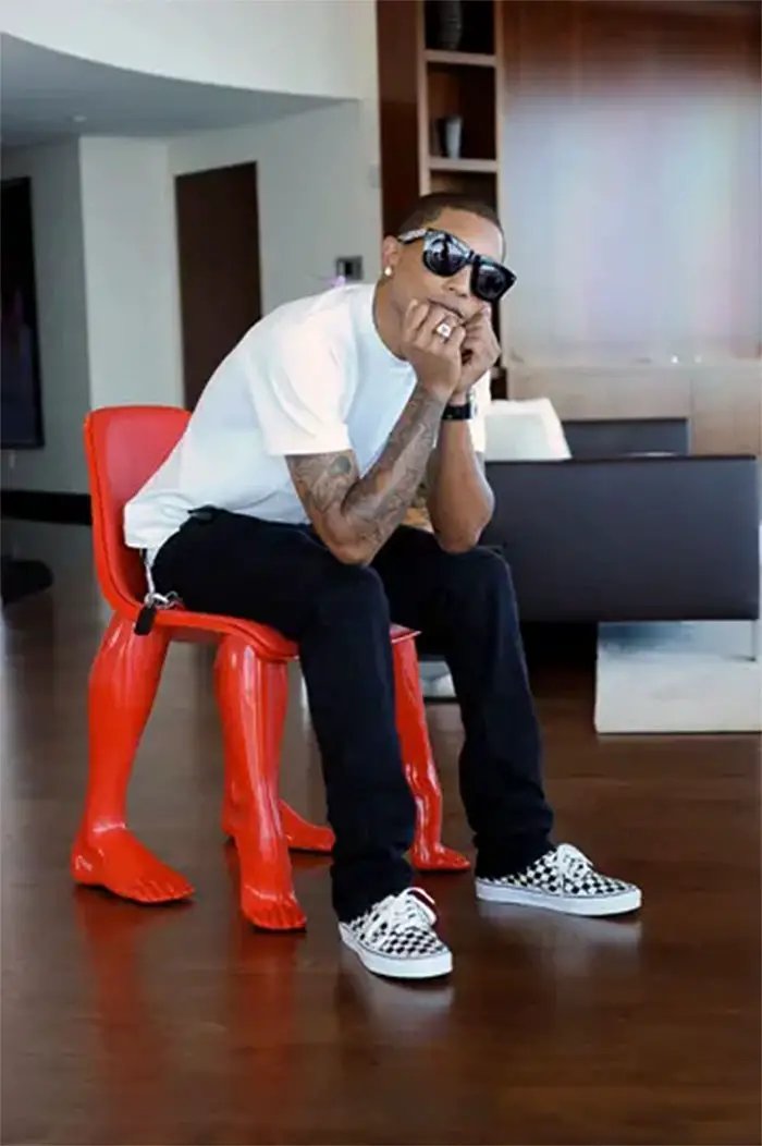 Pharrell Williams, sitting in a chair of his own design