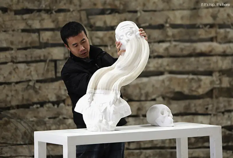 Chinese artist Li Hongbo stretches a paper sculpture work on the outskirts of Beijing