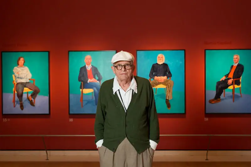 David Hockney stands in front of some of his 82 portraits, photo by David Parry