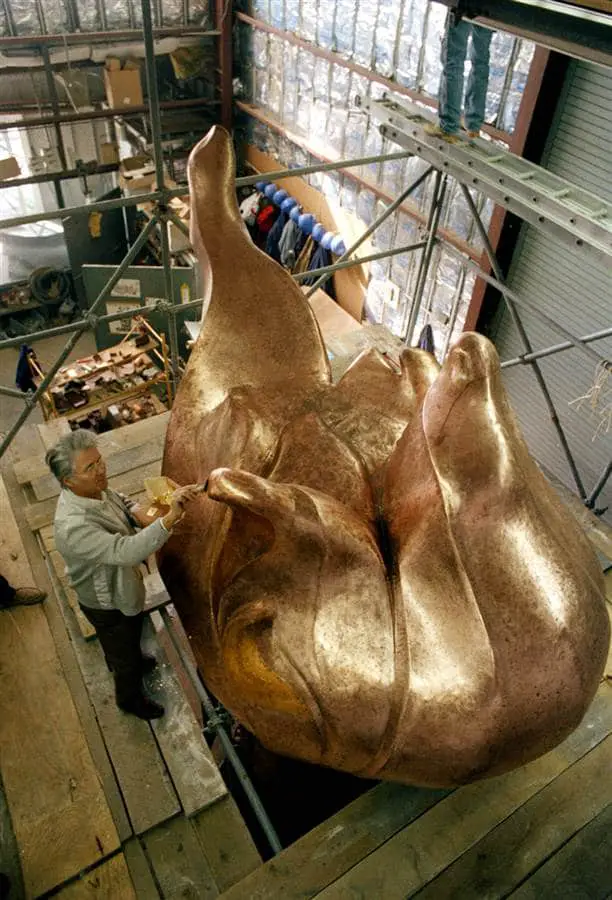 Robert Gohard, a member of a French restoration team, puts finishing touches of gilding on the statue's new torch.