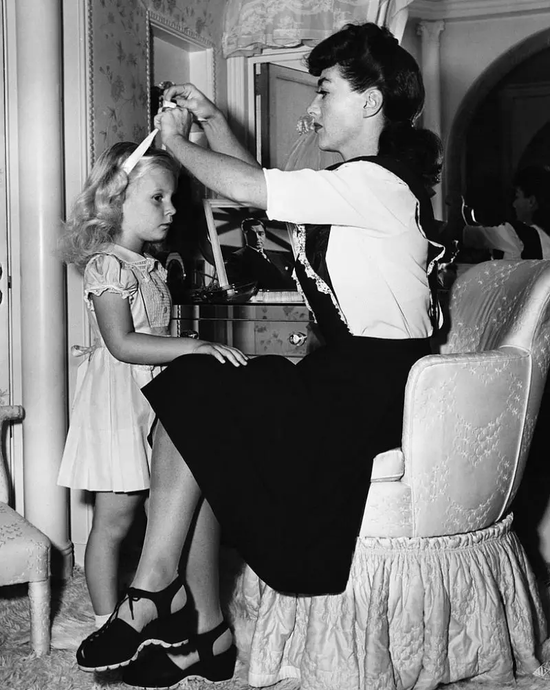 Joan tying ribbon in christina's hair