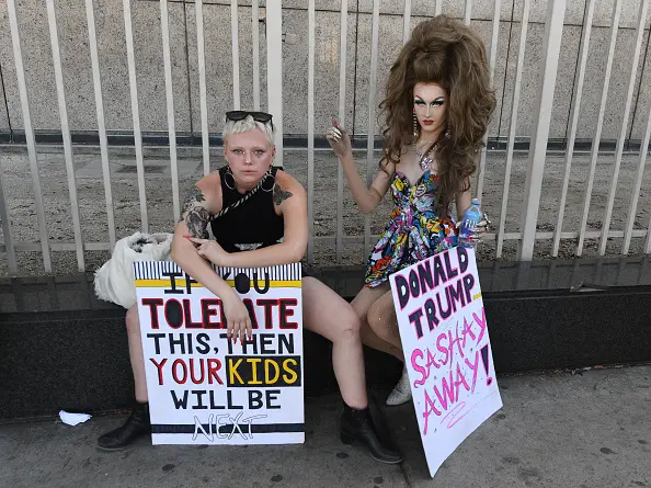 Protesters take a break during a march and rally against the separation of immigrant families, outside the ICE detention facility (back) in Los Angeles, California, on June 30, 2018, - (Photo by Mark RALSTON / AFP)