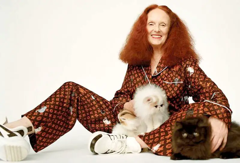Grace Coddington with her Persian cats poses in the LV Catogram silk pajamas