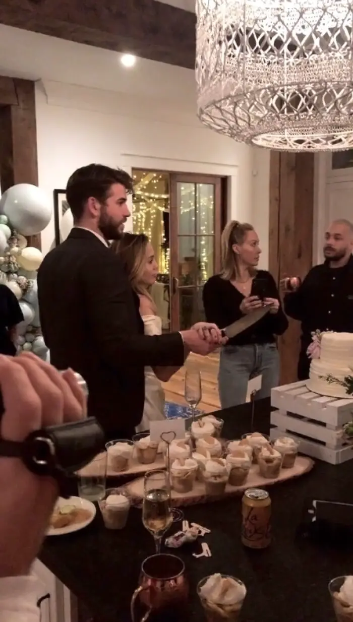 Miley and Liam cut the wedding cake 