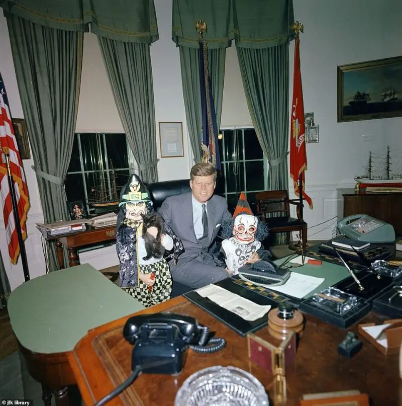 Caroline and John Jr., dressed in costume, visit President John F. Kennedy in the Oval Office on Halloween in 1963.