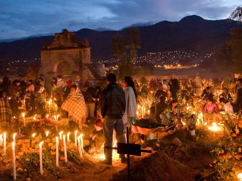 Family members share stories at a gravesite in Oaxaca, photo by Tom Dietrich