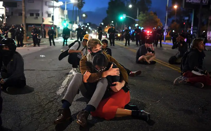 A protesting couple huddles on Fairfax Ave