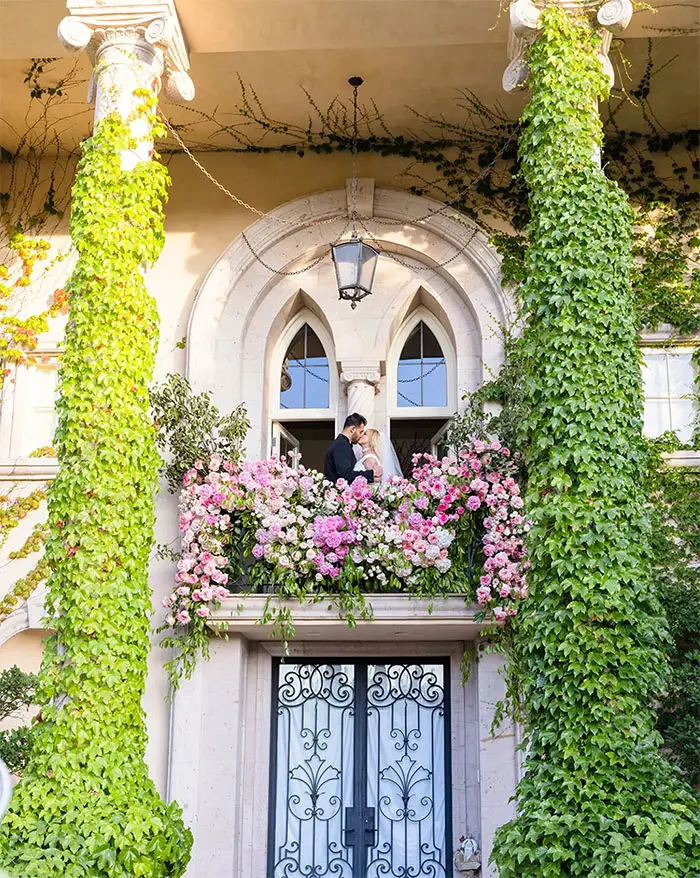 The newlyweds share a kiss on the balcony