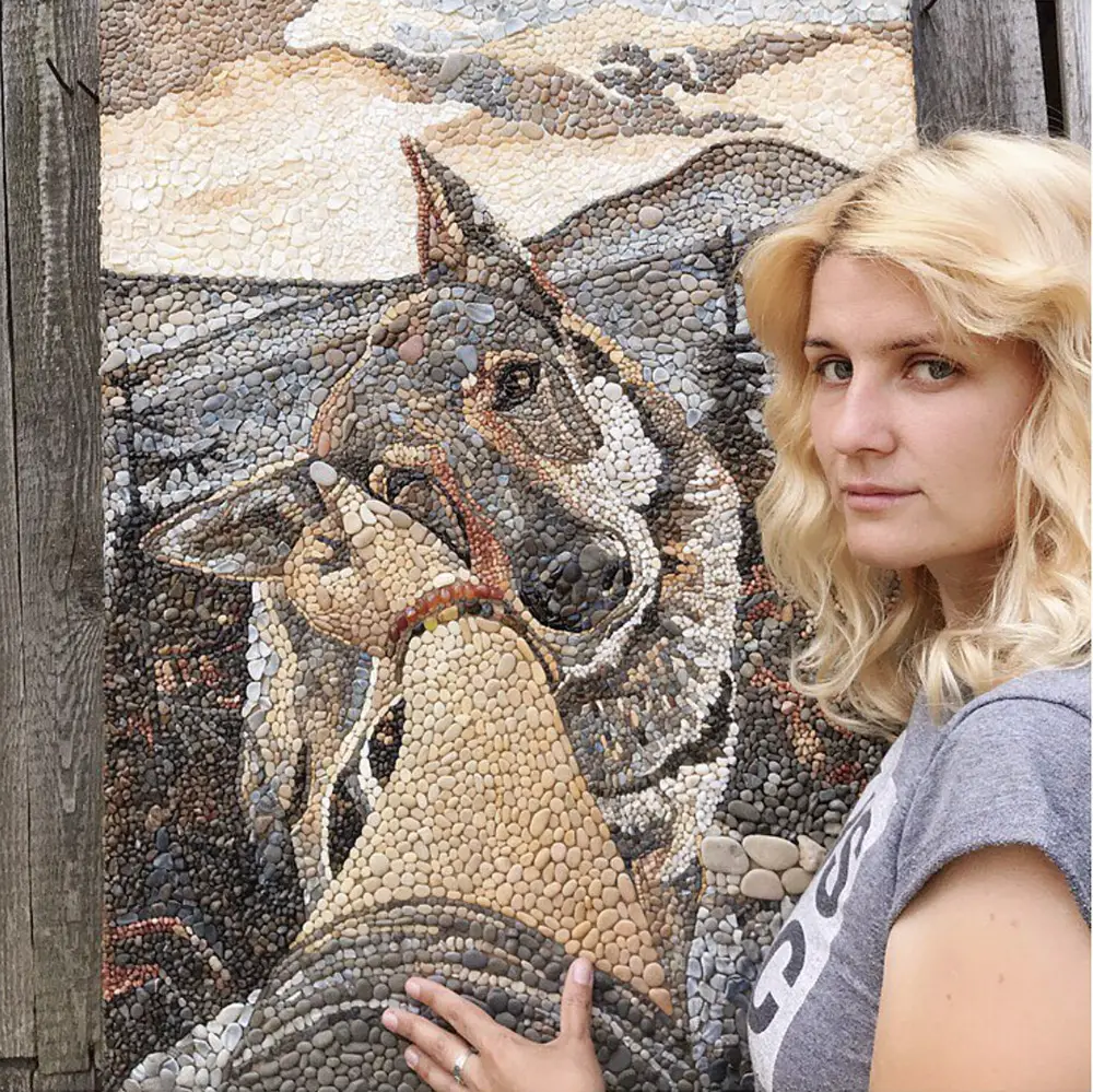 Mosaic Artist Anna with the final framed pebble portrait of Sitka.